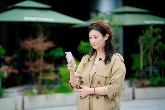年轻女性手持手机在城市景观