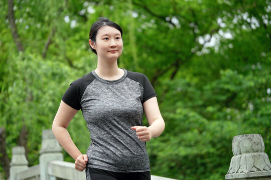 年轻女性在户外绿色公园慢跑健身