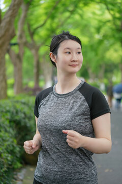 年轻女性在绿色公园慢跑