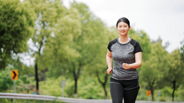 公园小径上慢跑健身的女性