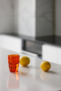 橙色水杯和柠檬的桌面特写