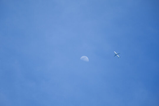 飞机飞过月亮蓝天背景