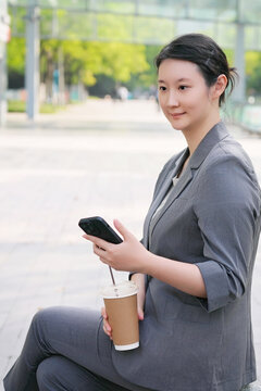 户外自信女性使用手机咖啡休息