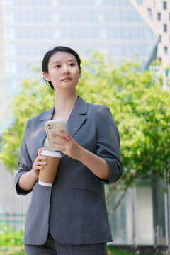 职业女性带着智能手机和咖啡出门