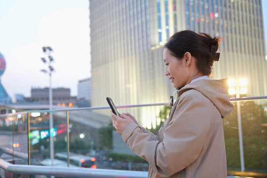 城市景观使用手机发送短信的女性