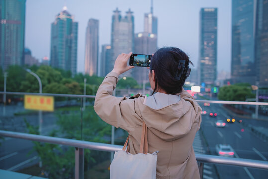 户外观光游客用手机捕捉城市景观