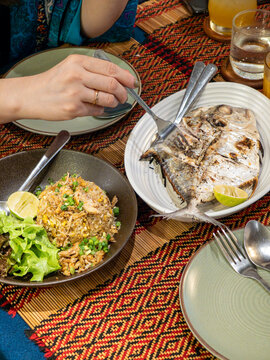 餐桌上放在餐盘里的泰式烤鱼