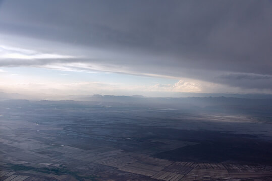 航拍积雨云下中国新疆的田野河流