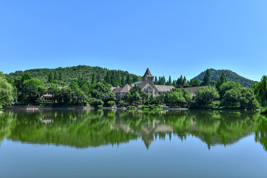 晴朗天空下的湖水绿树别墅