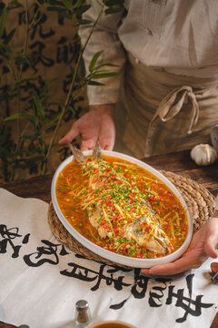 复古农家背景手端四川菜豆瓣鱼