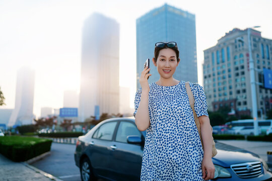 行走在城市景观中电话沟通的女性