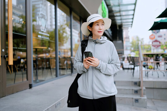 女子用智能手机享受外咖啡出时光