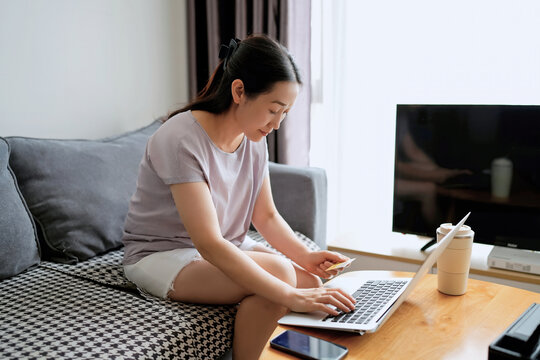 年轻女性在家用笔记本电脑工作