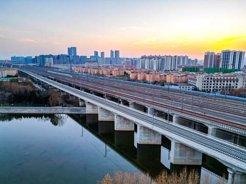 夕阳下行驶的高速列车穿越铁路