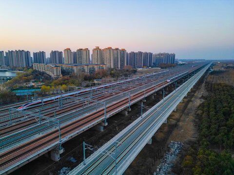 夕阳下行驶的高速列车穿越铁路