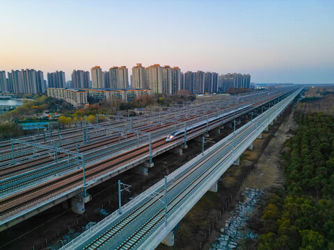 夕阳下行驶的高速列车穿越铁路