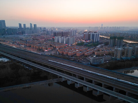 落日下的郑州城市高铁