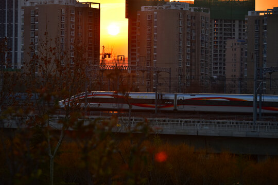 夕阳下行驶的高速列车穿越铁路