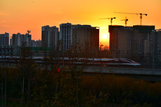 夕阳下行驶的高速列车穿越铁路