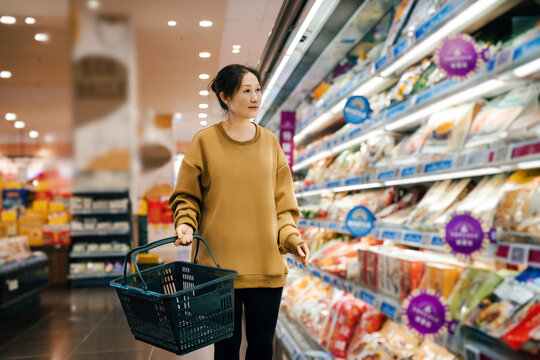 女性在超市货架旁选择健康食品
