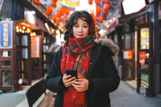 年轻女人在夜晚光线使用智能手机