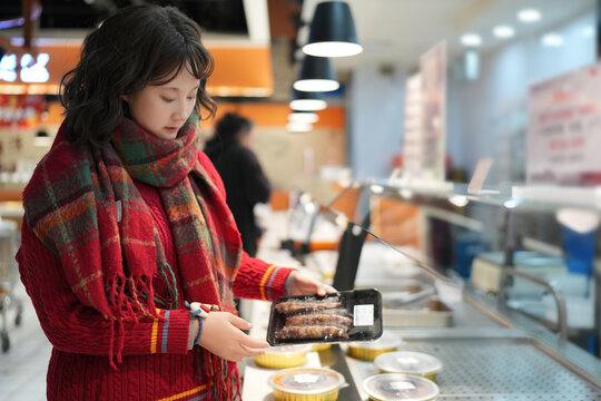年轻女性在超市购买冷冻食品