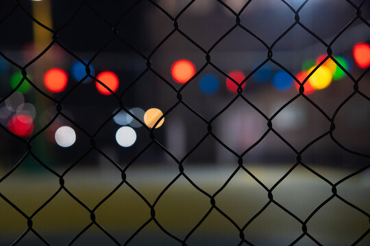 夜晚球场外的铁丝网光斑