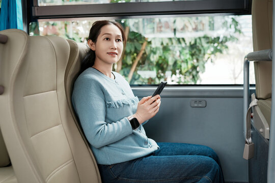 女人在公共汽车使用智能手机旅行