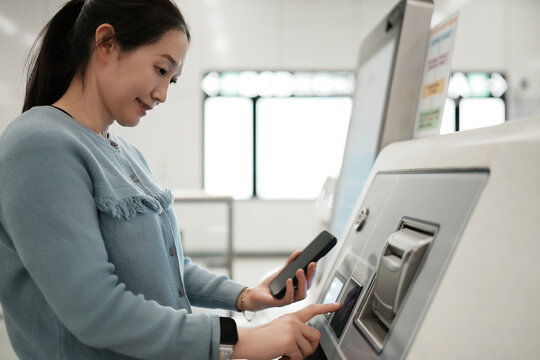 女性使用现代支付亭进行高效交易