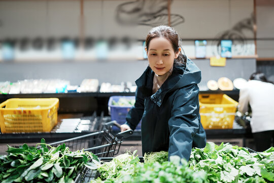 女人在农产品超市挑选沙拉蔬菜