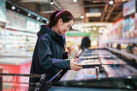 女人在超市冰箱选择食品杂货