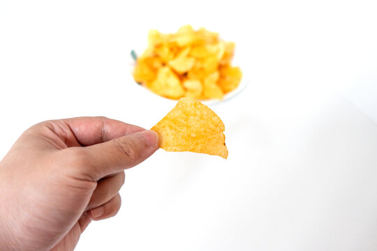 一盘白色彩绘碟子里装着一堆膨化薯片零食