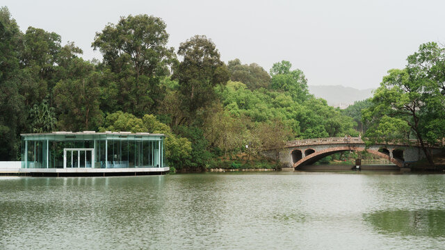湖畔玻璃建筑与石桥风景图