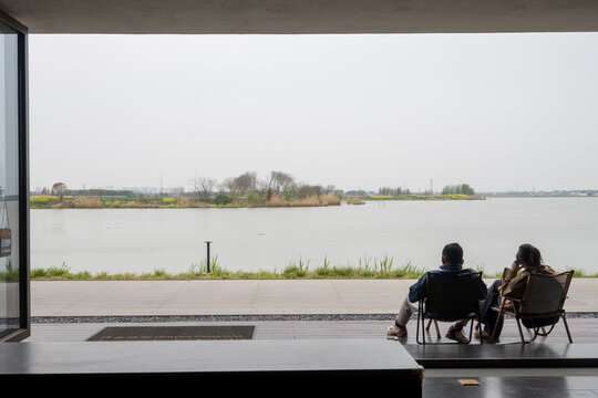 二人临湖惬意闲坐赏景