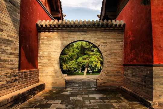 古建圆门后的绿意景致