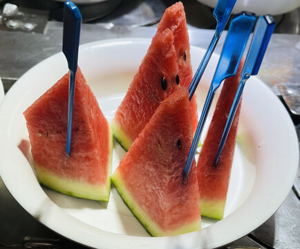 插着蓝叉的新鲜西瓜切块