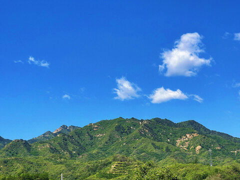 蓝天白云下的翠绿山峦