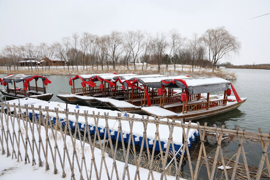 雪覆游船静泊湖边景致
