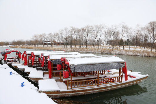 雪覆河畔古色游船静泊