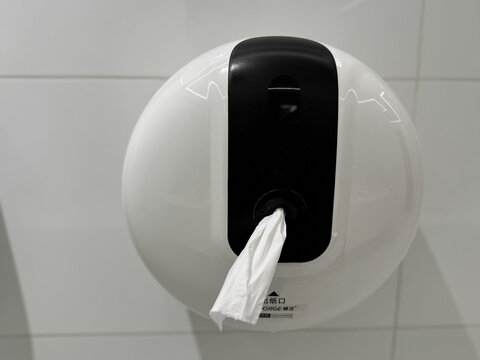 白色墙面的圆形纸巾盒特写