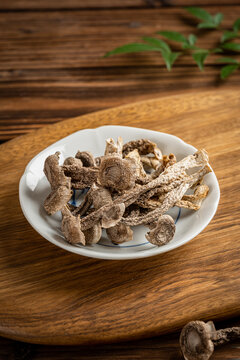 木板上瓷盘中的干货鹿茸菇