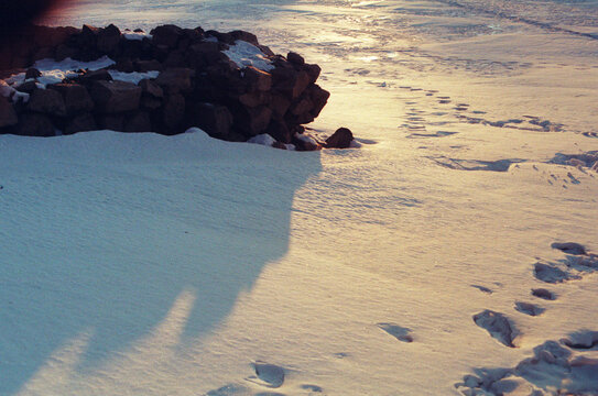 雪地中的石块与夕阳足迹
