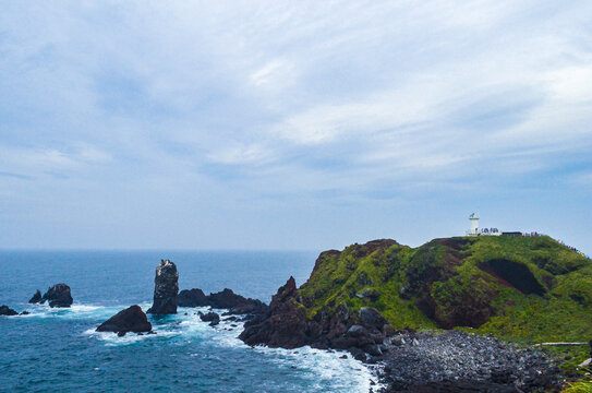 海岸灯塔与嶙峋礁石美景韩国济州岛风光