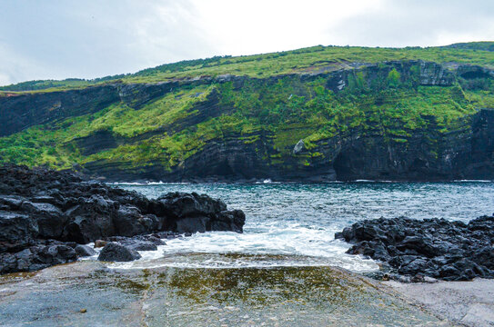 海岸边的绿崖与礁石景观济州岛牛岛