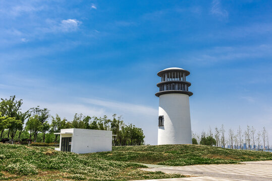 蓝天下的白色灯塔与小屋