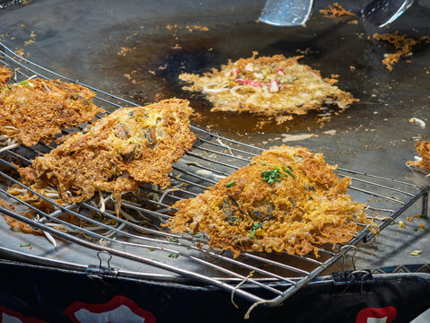泰国街头美食摊上正在烹饪的酥脆泰式蚝烙