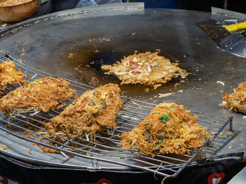 泰国街头美食摊上正在烹饪的酥脆泰式蚝烙
