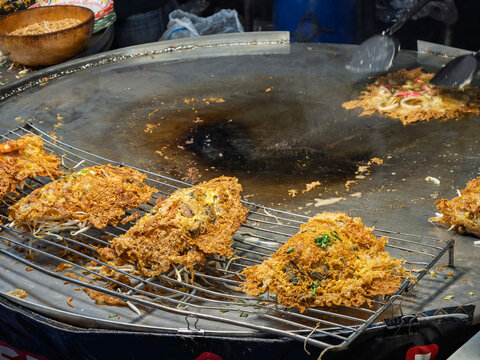 泰国街头美食摊上正在烹饪的酥脆泰式蚝烙