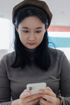 专注的亚洲女性使用智能手机