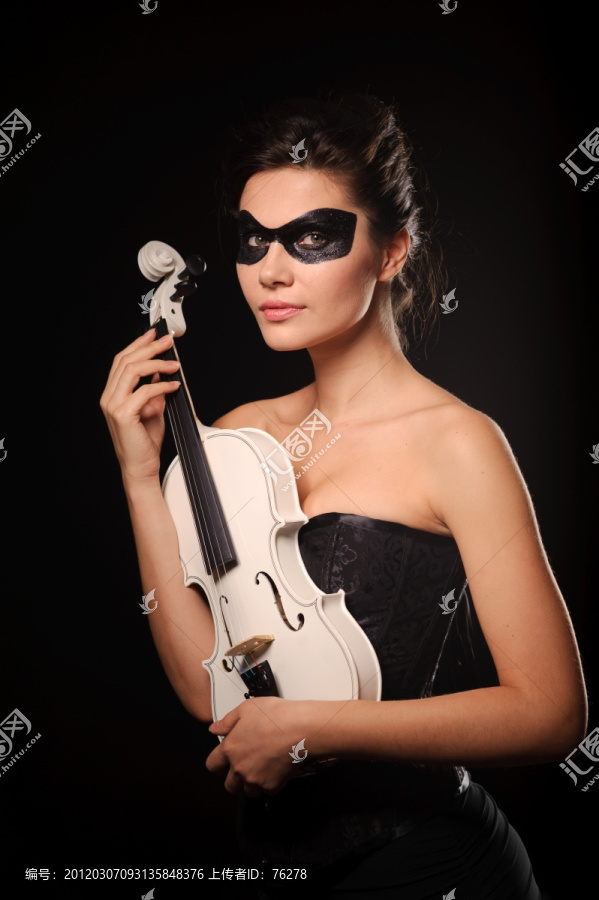 戴着黑色面具的性感女人拿着白色小提琴